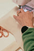 Leim Sewing workshops - jumpsuit sewing workshops - Person using a sewing machine with a close-up of hands and a watch.